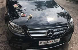 zdjęcie czarnego Mercedesa z przodu przystrojonego do ślubu