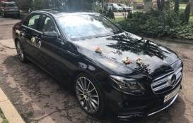 zdjęcie czarnego Mercedesa z oku przystrojonego do ślubu